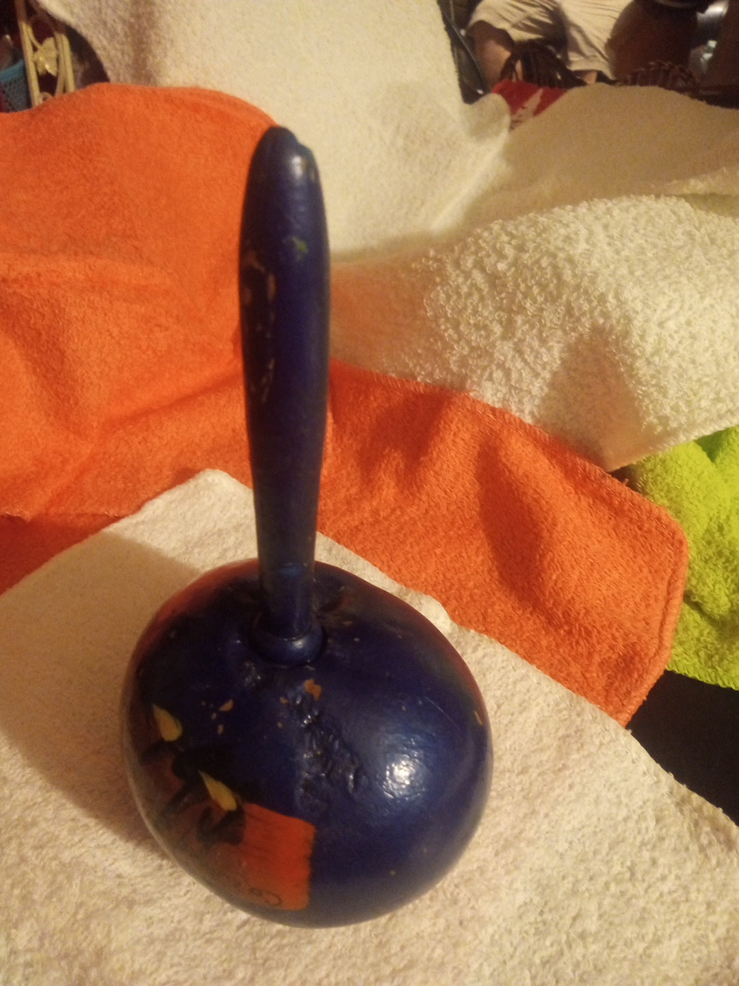 Side view showing the handle and rounded body of blue maraca